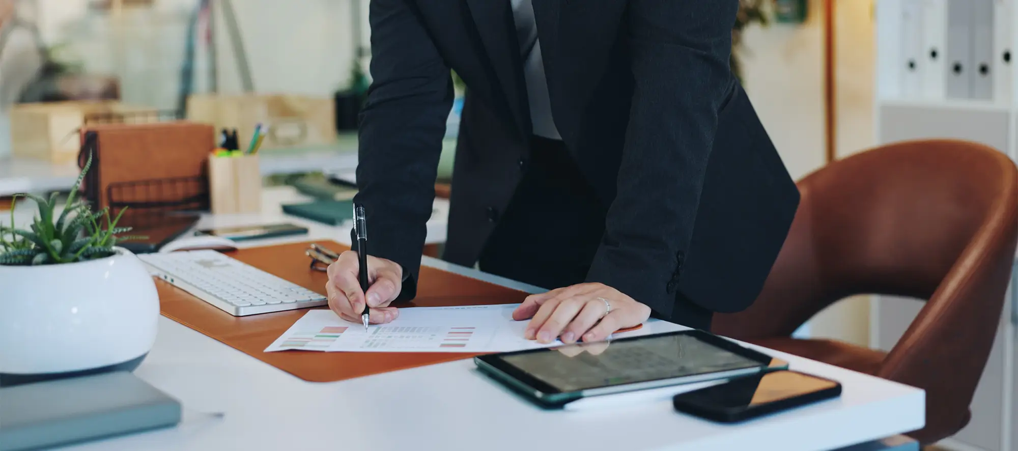 Business woman looking over paperwork at an office desk.