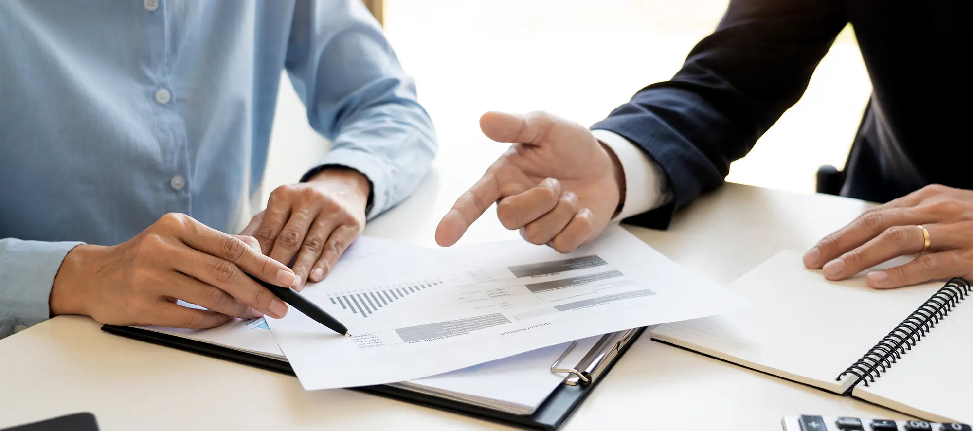 Two business people at a desk looking at paperwork.