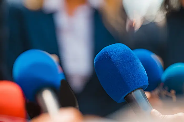 News microphones pointed at people