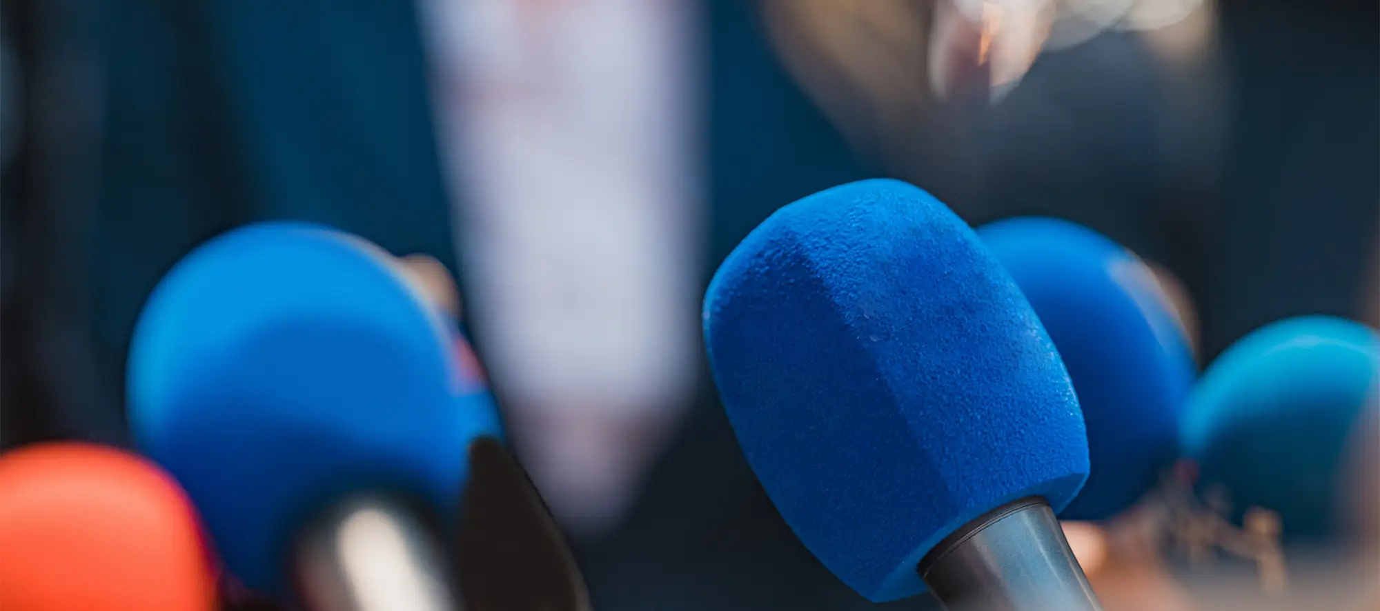 News microphones pointed at crowd