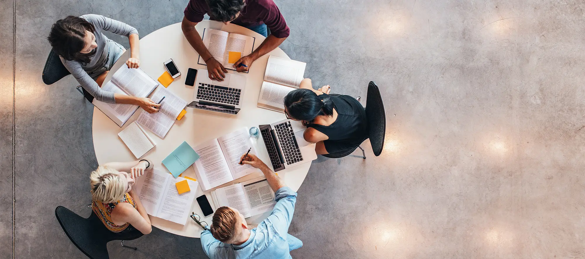 Top down view of group of students at a table with study materials.