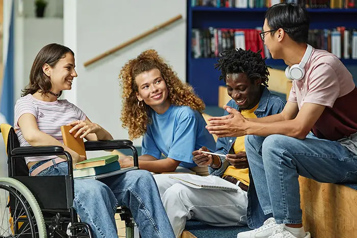 Diverse group of young people chatting in college library.
