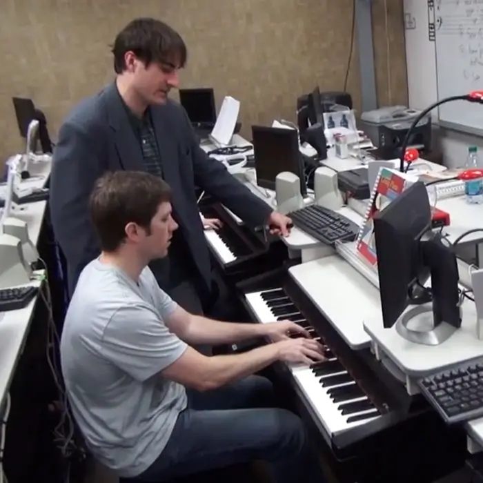 Travis Minter being instructed on piano