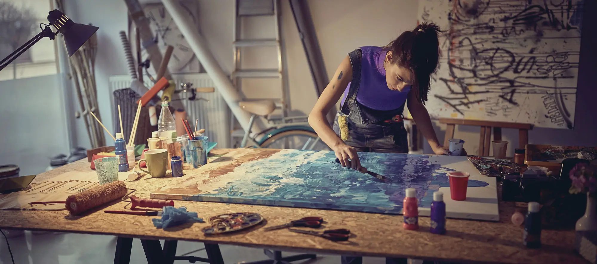 Visual artist painting on large canvas