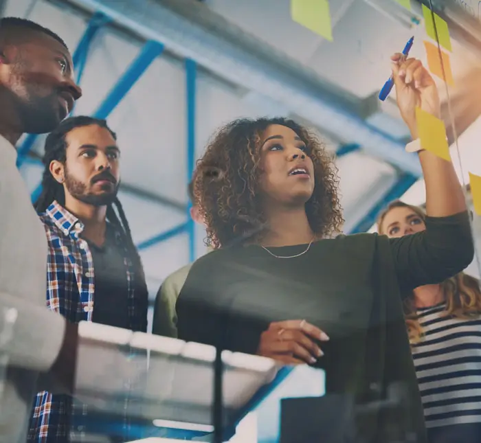 Group of marketing professionals outlining a plan with sticky notes