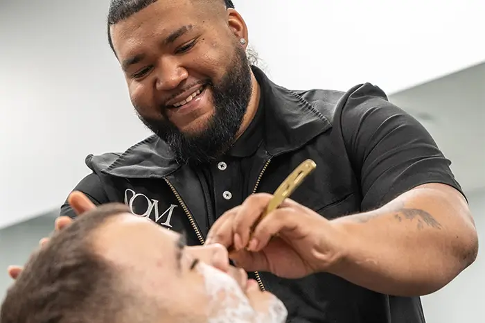 Man getting a clean shave at the salon at com.