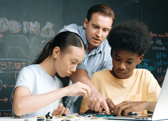 Teacher with two young students on laptop