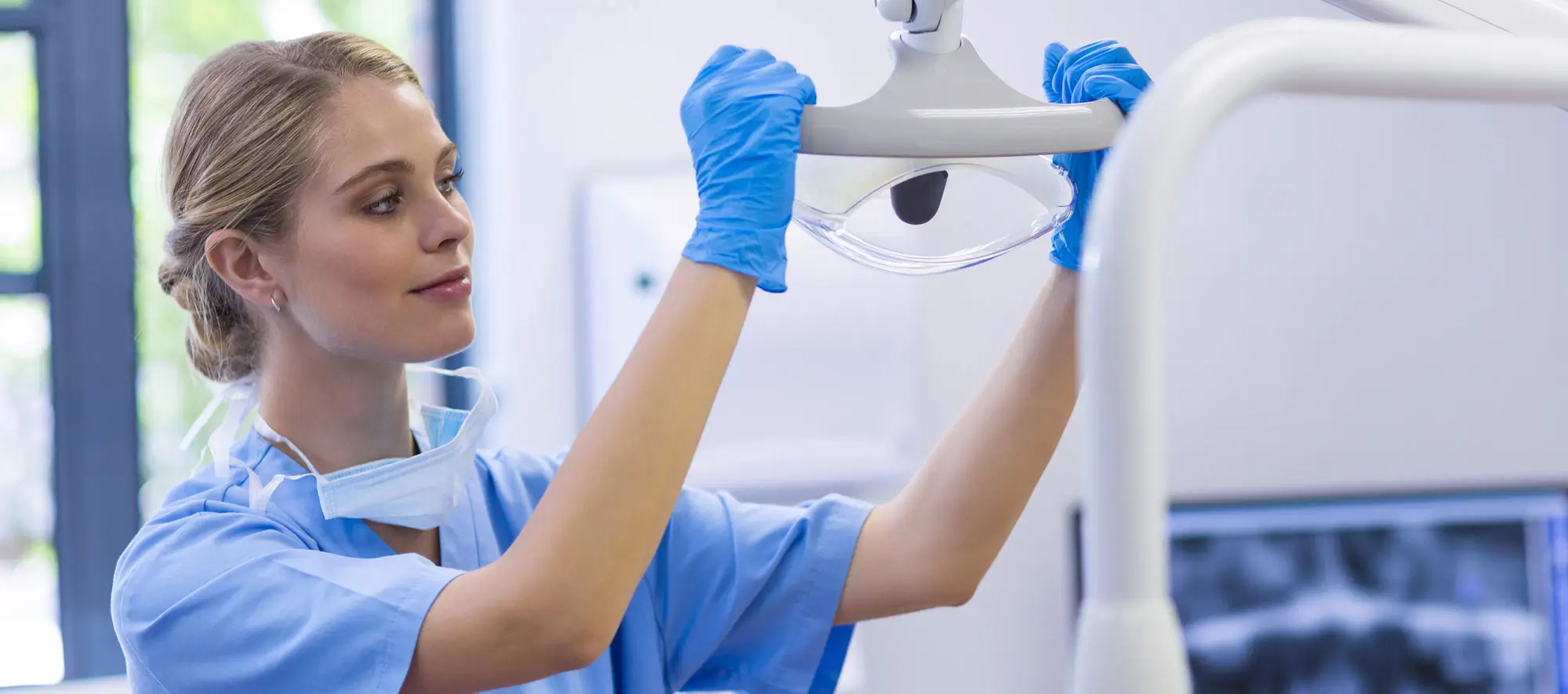 Female nurse adjusting dental light