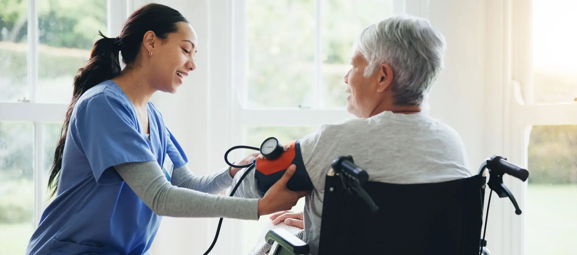 Woman, caregiver and senior in wheelchair for blood pressure.