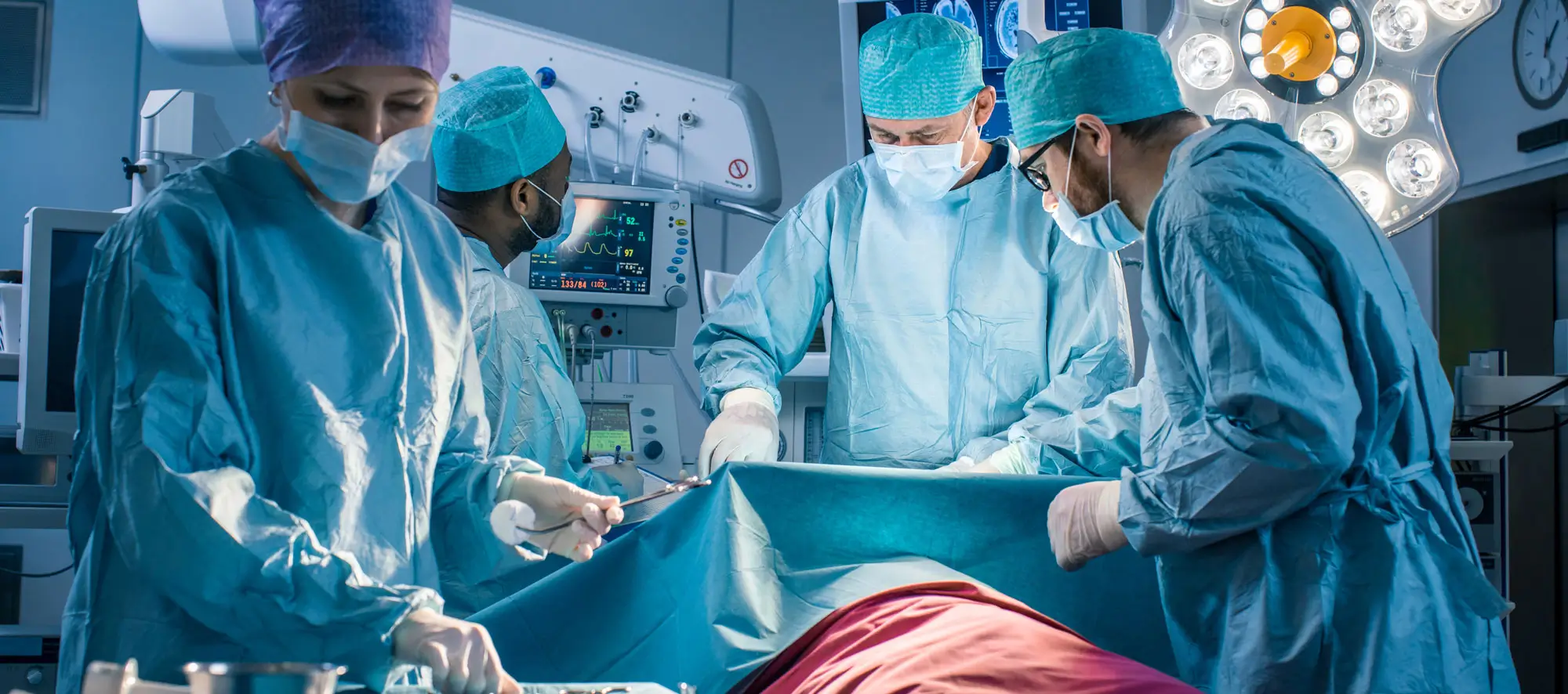 Team of Professional Surgeons Performing Invasive Surgery on a Patient in the Hospital Operating Room.