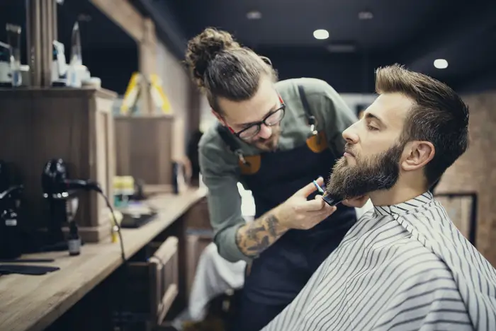 Barber cutting a man's beard