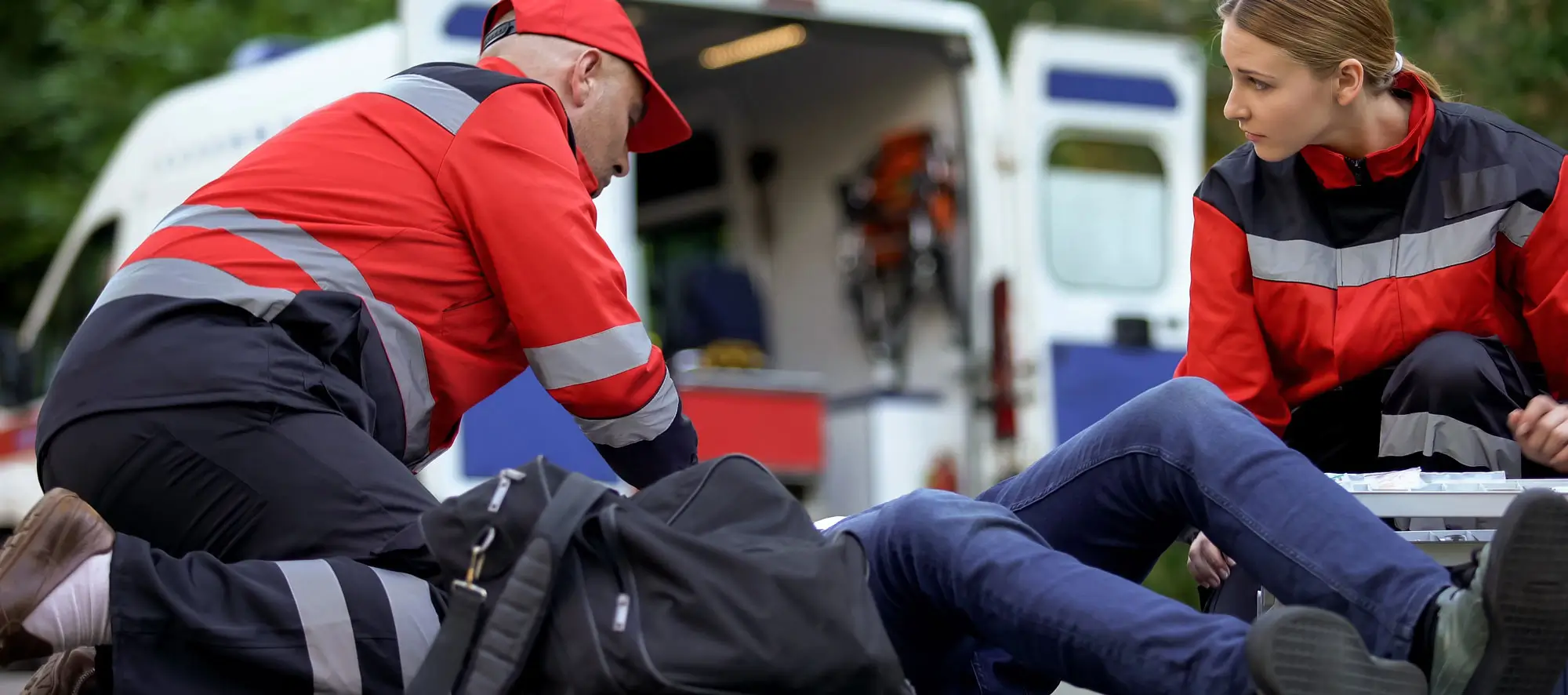 Paramedics helping patient on road, first aid trainings, medical qualification.