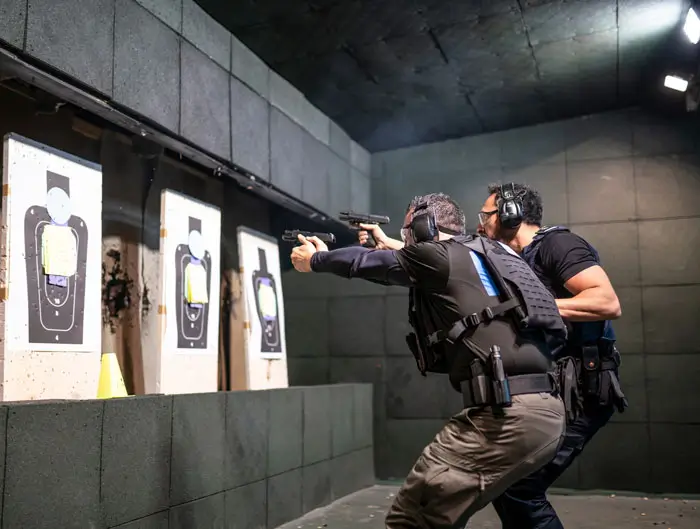 Police training in shooting gallery with short weapon.