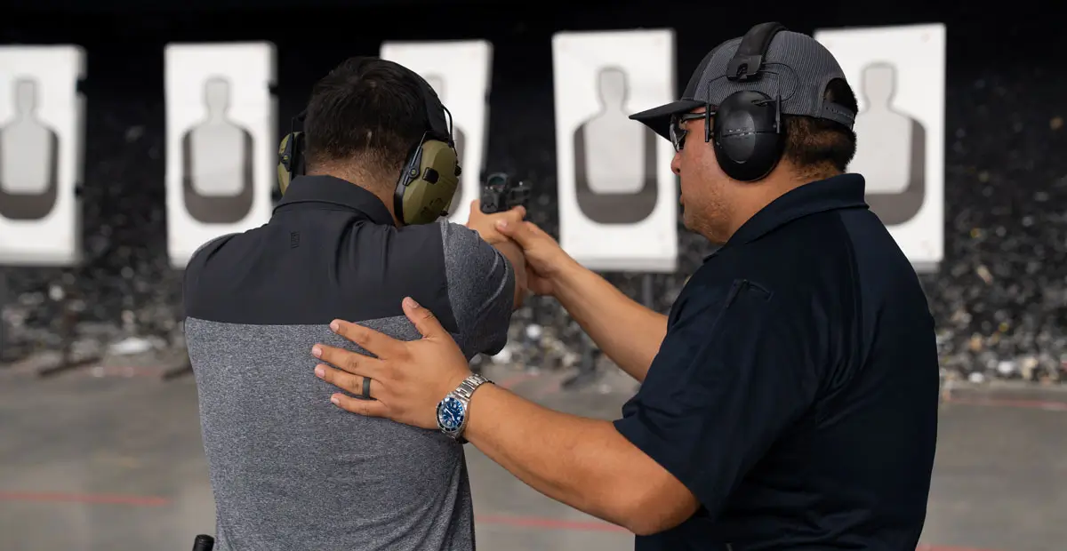 Instructor with man shooting gun