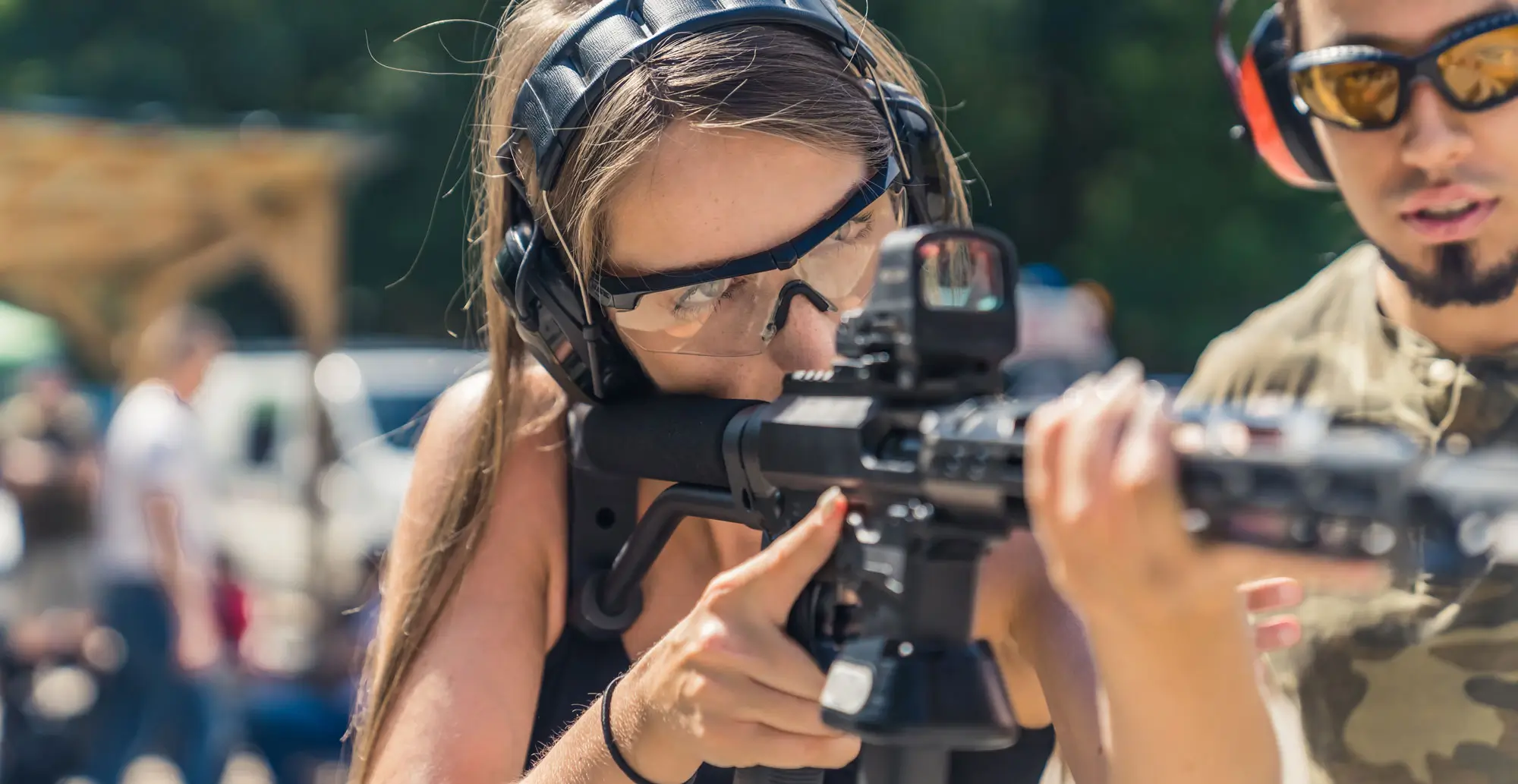 Instructor with woman shooting a rifle