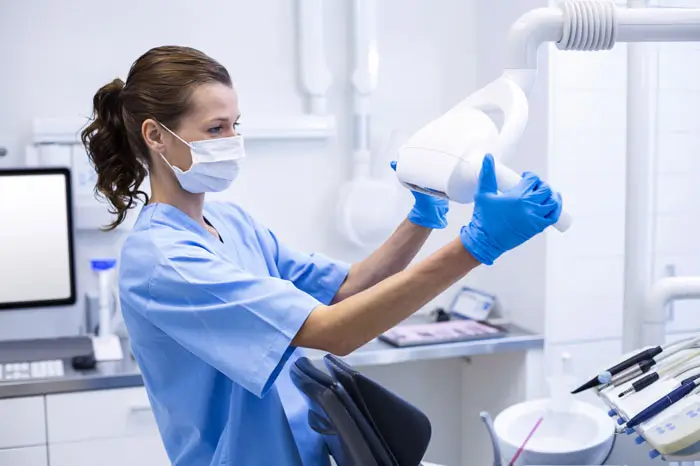 Dental Assistant adjusting x-ray machine