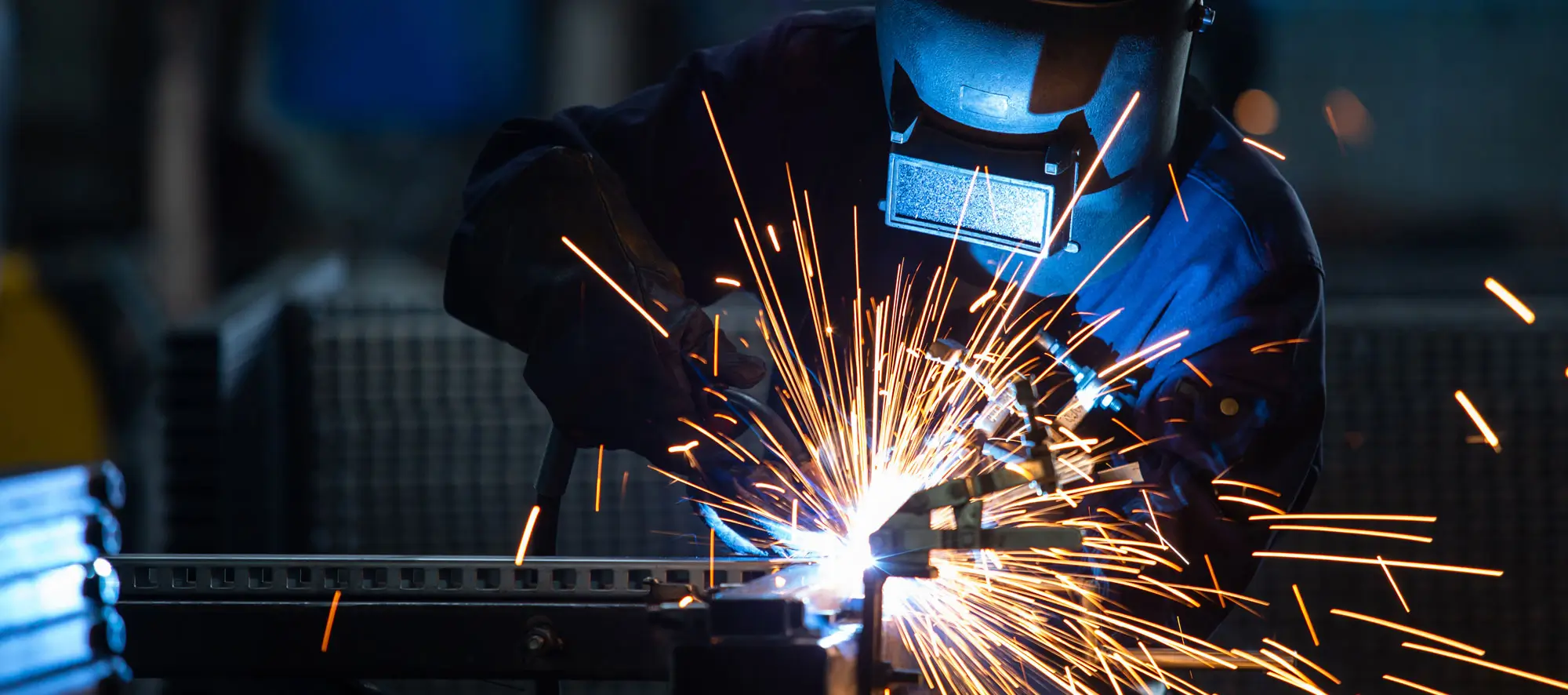 Workers wearing industrial uniforms and Welded Iron Mask at Steel welding plants.