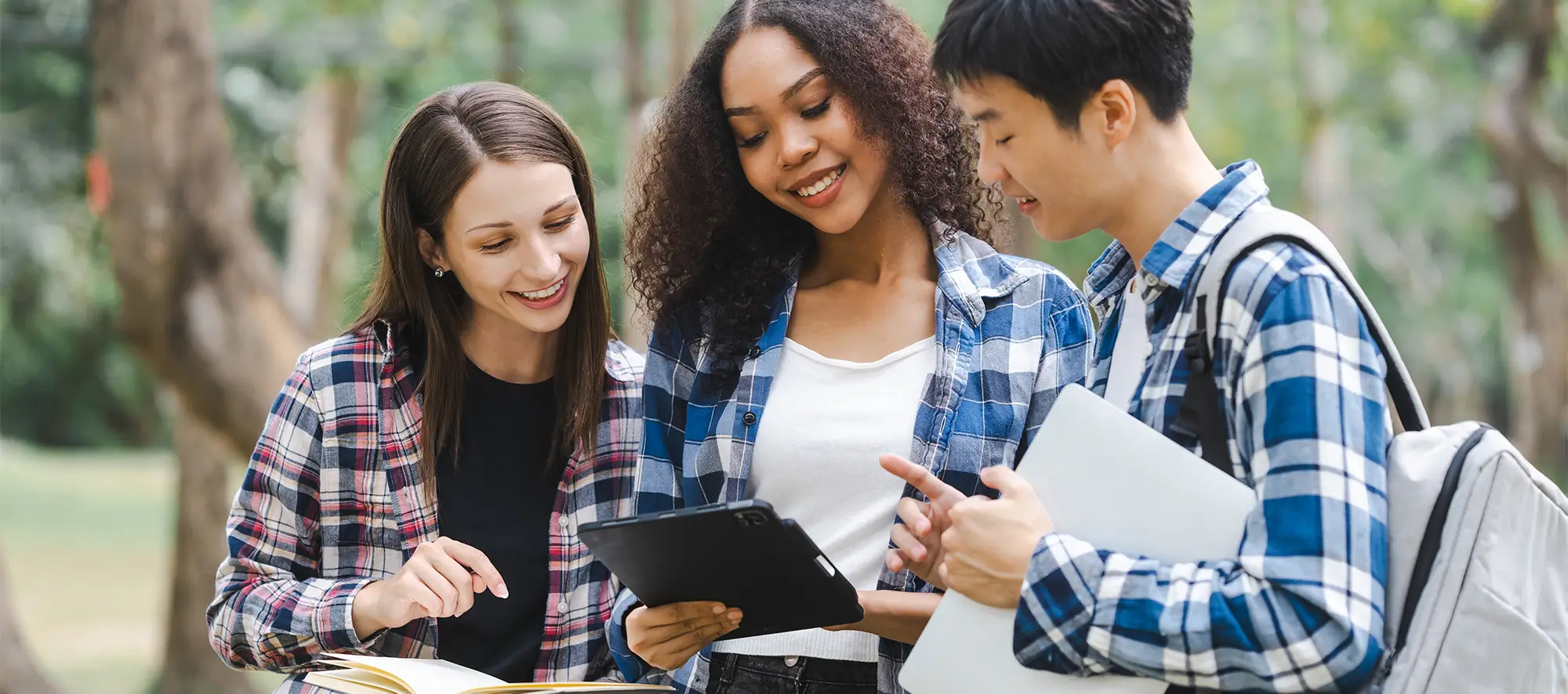 Students on campus looking at a tablet.