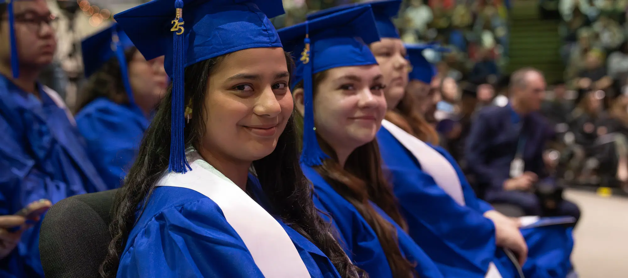 Smiling graduates at commencement ceremony.
