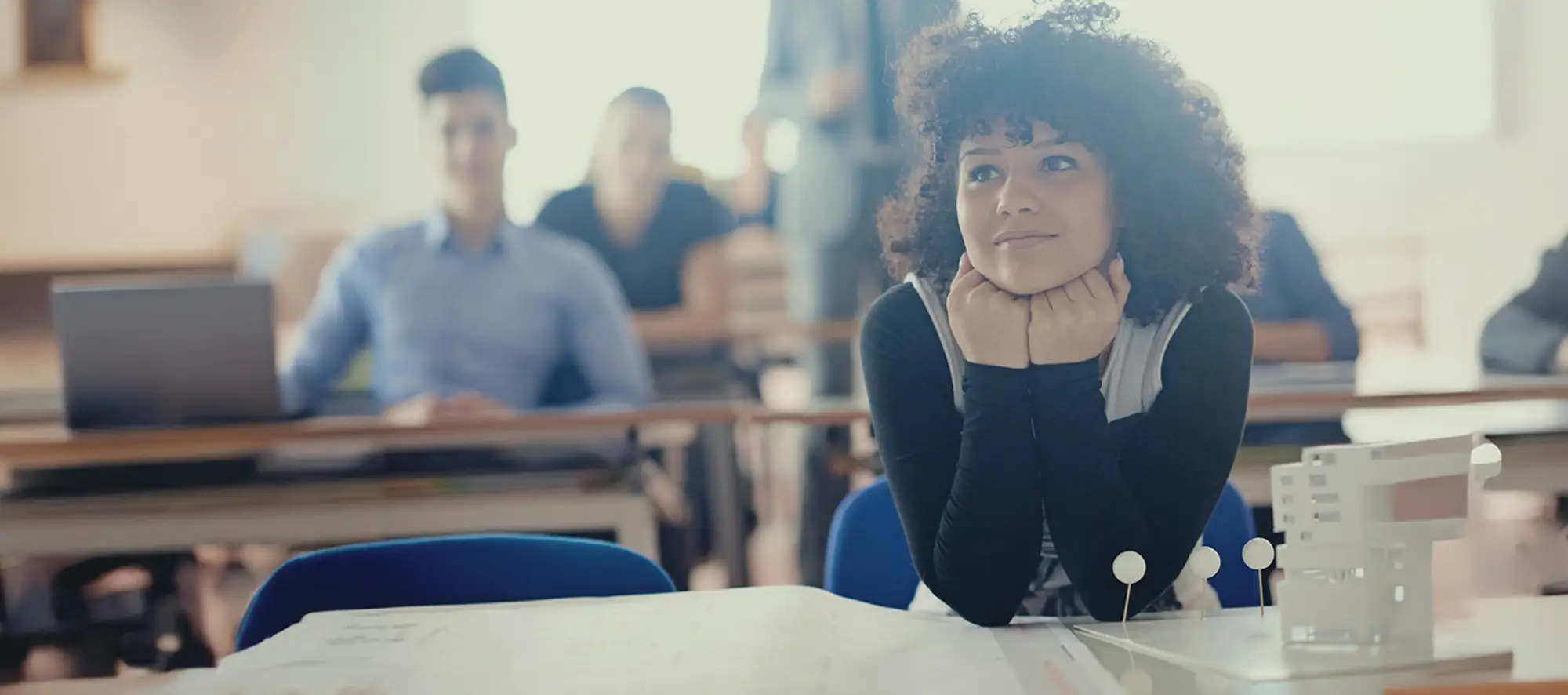 Student in classroom at desk watching a lecture