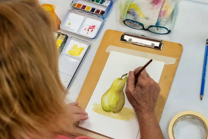 Woman painting a pear scene