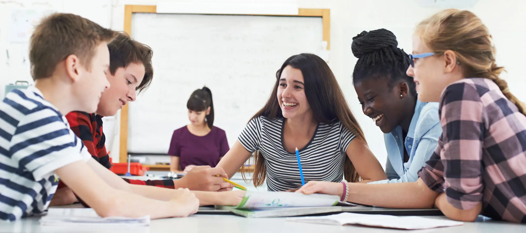 Group of high school students studying together at large table