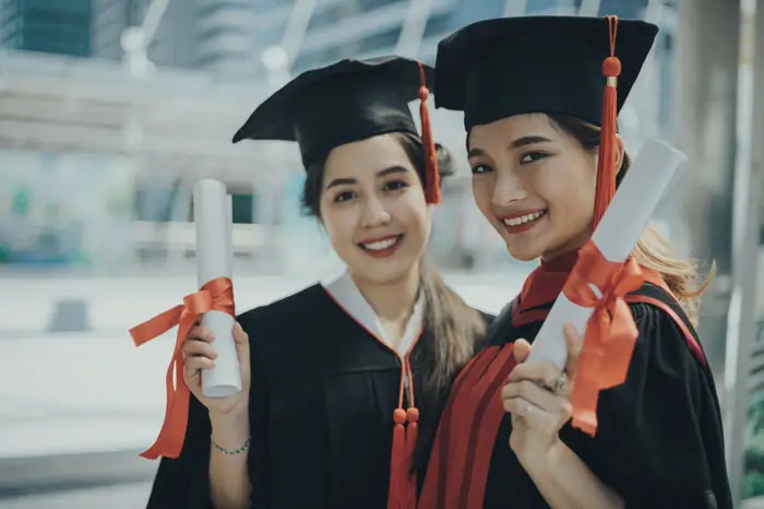 Adult Education students in cap and gown with degrees