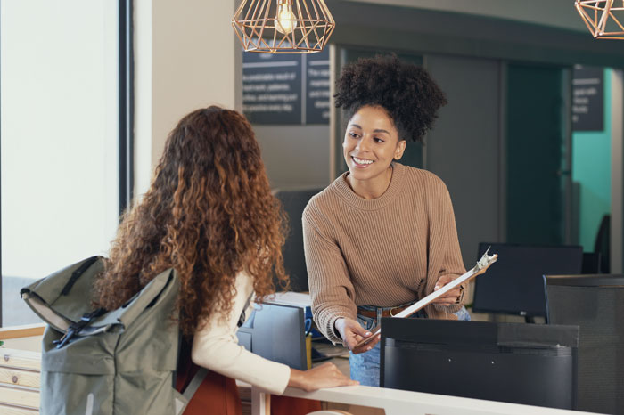 Young woman checks in at admissions front desk