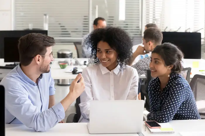 Students discussing online project at workplace