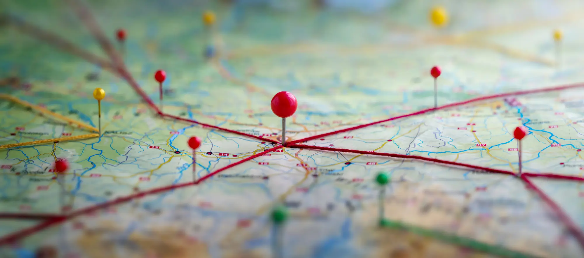 Paper map with colorful pins in various locations.