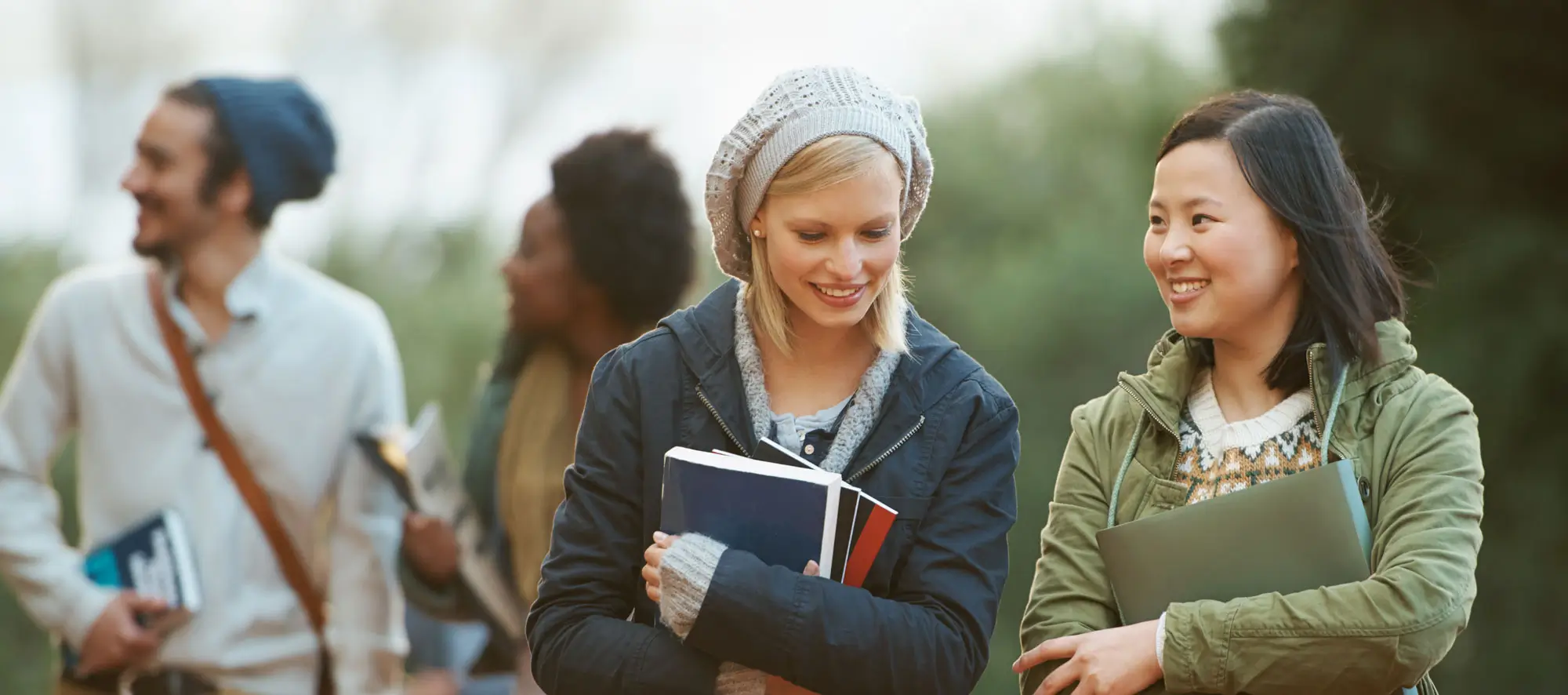 College life. Shot of a college students between classes on the campus grounds.