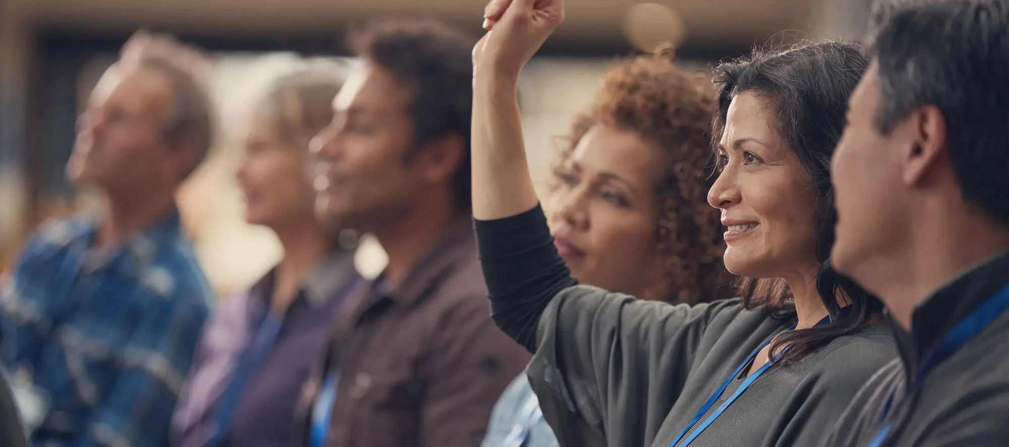 Business woman In Presentation At Conference Raising Hand To Ask Question