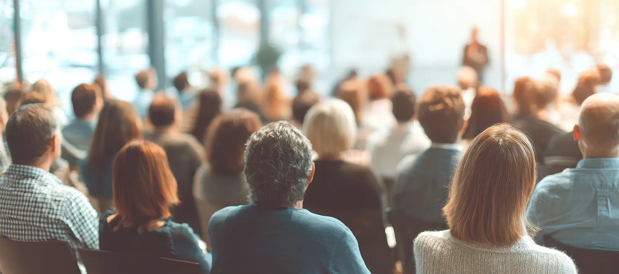 Business professionals attending a seminar audience engaging in training session led by an expert