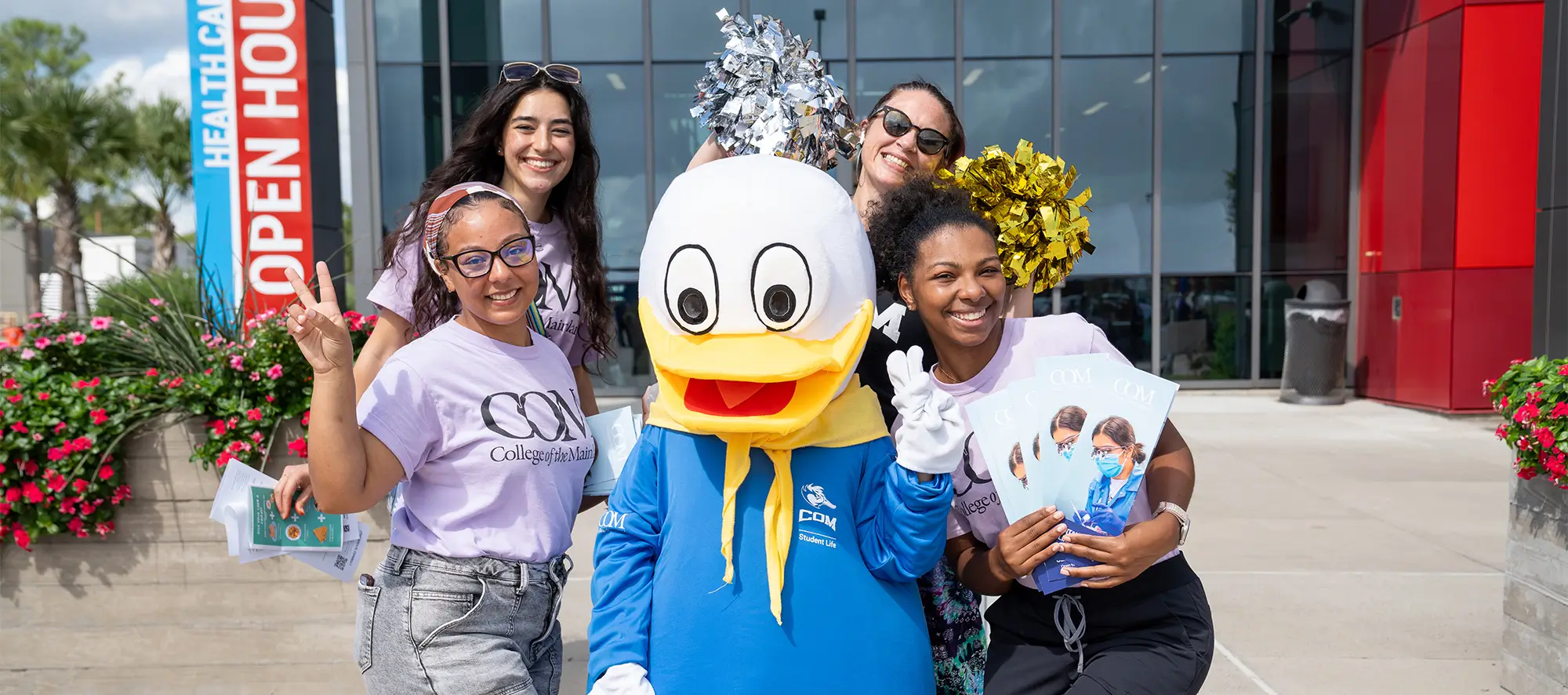 Students posing with College of the Mainland's duck mascot.