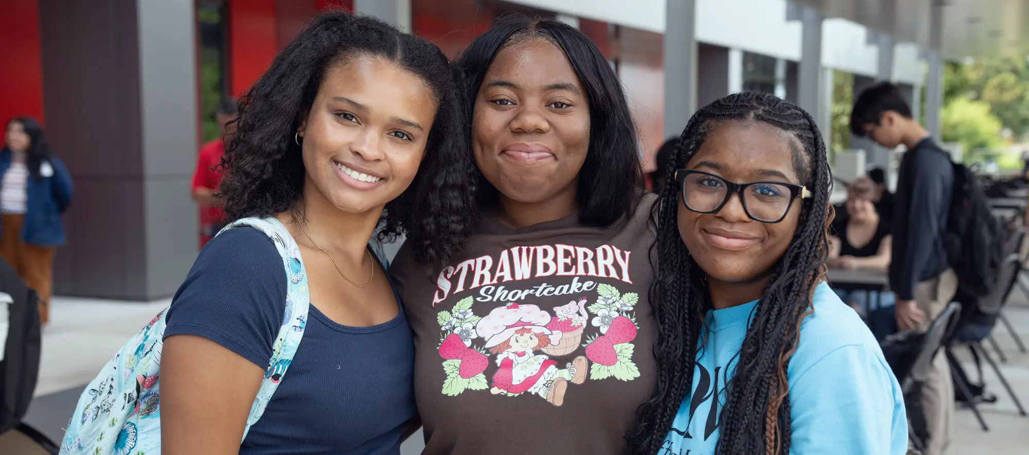 Three female students at event outside