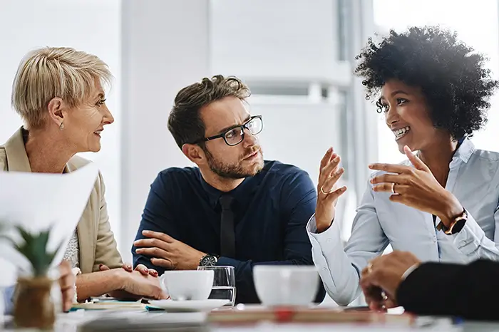 three people talking in an office.