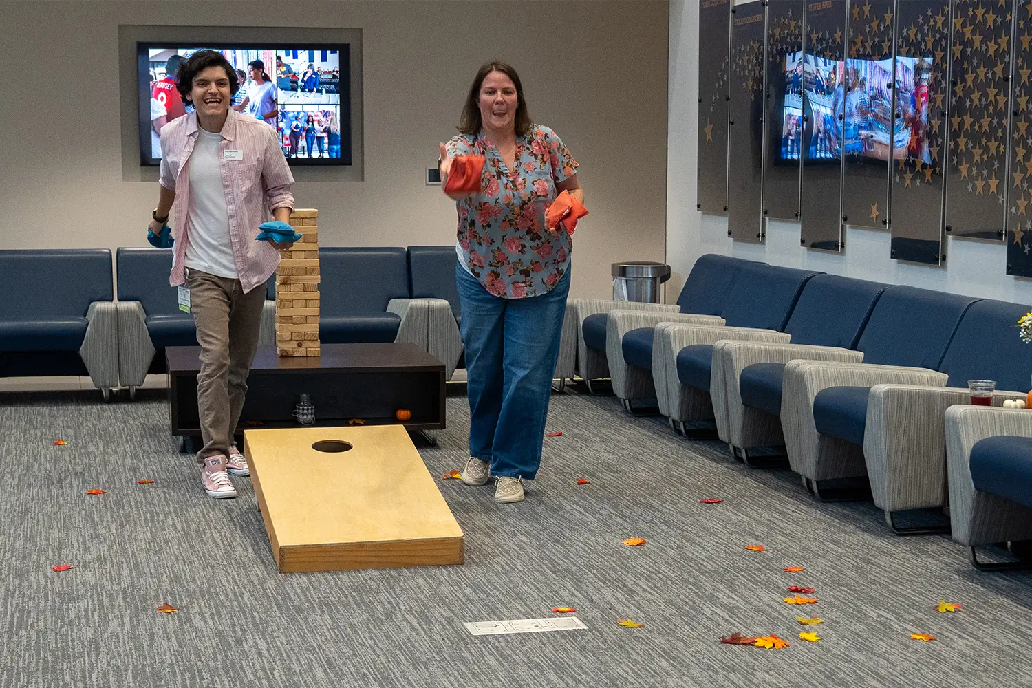 Two COM employees playing corn hole