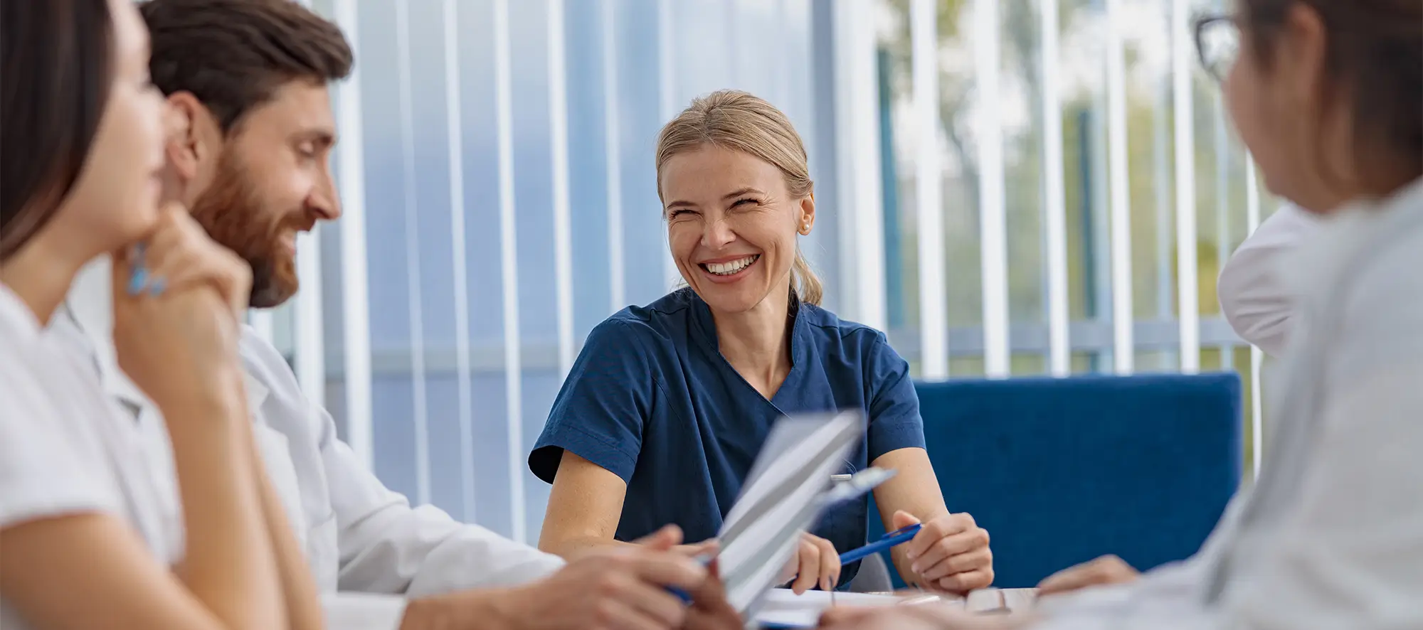 Group of professional staff talking at an office table.