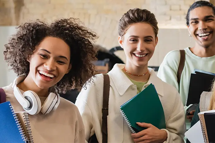 Group of smiling students with books in hand