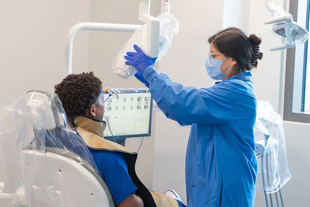 COM dental hygiene student Gabrielle Garza performs an x-ray on a patient.