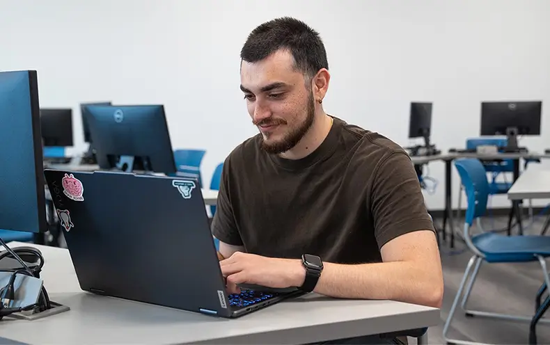 RPA Career Training Student Kevin Salazar Typing on his Laptop