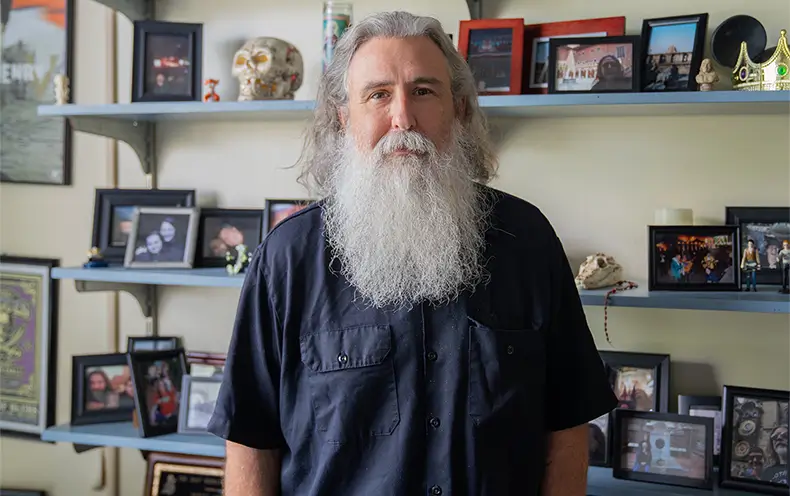 College of the Mainland Professor Bernie Smiley stands in his office surrounded by shelves filled with personal photos and mementos.