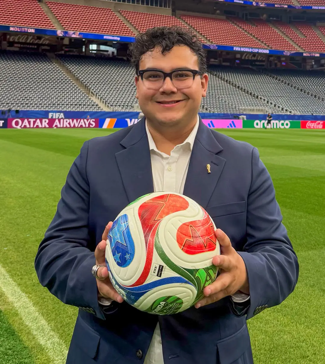 Hayden Victoria on the field at the Houston World Cup Stadium holding a World Cup soccer ball.