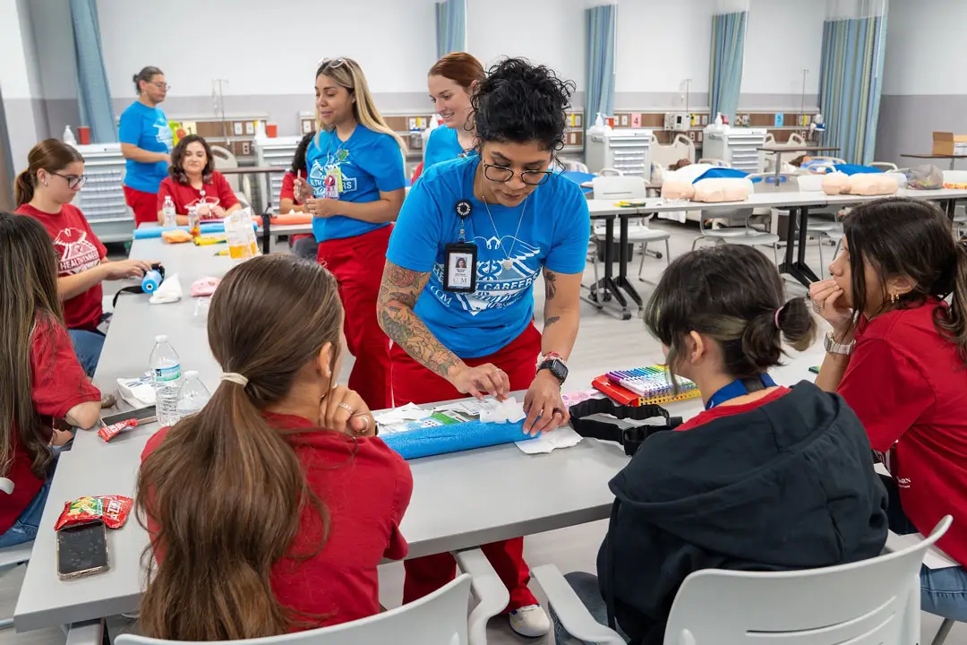COM nursing student Maralissa Medina demonstrates a stop the bleed tourniquet for students during the COM 2025 Health Professions Summer Camp.