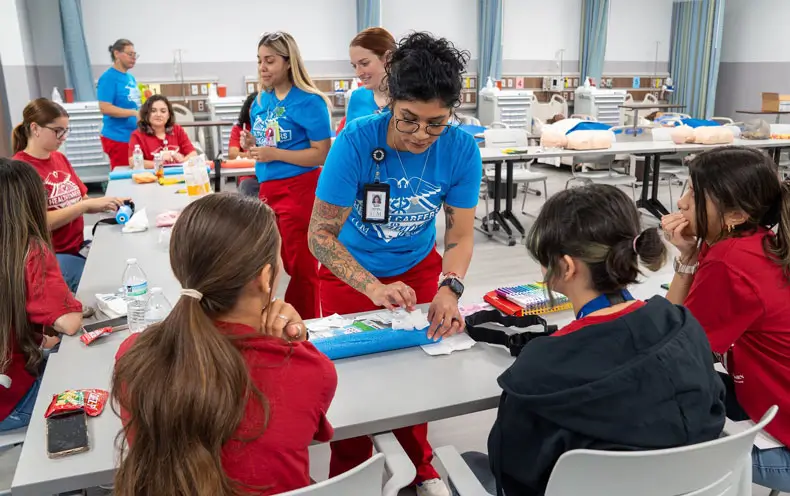 COM nursing student Maralissa Medina demonstrates a stop the bleed tourniquet for students during the COM 2025 Health Professions Summer Camp.