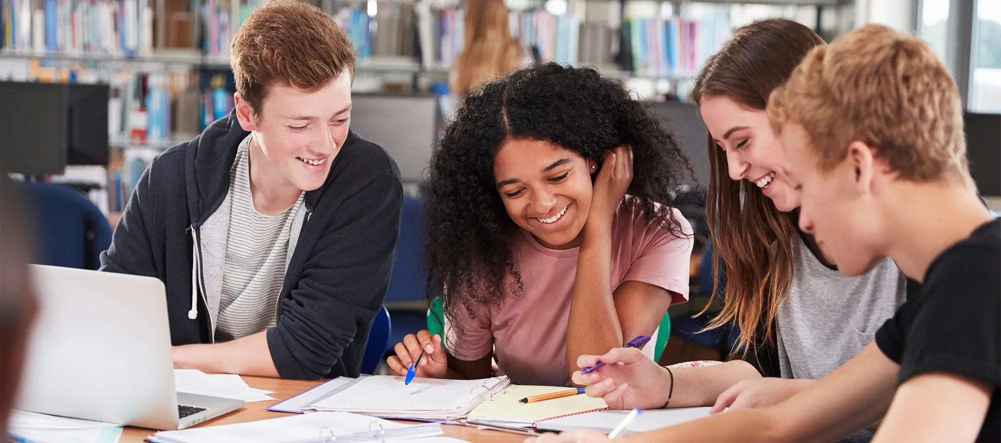 Students sitting at a round table in the library.