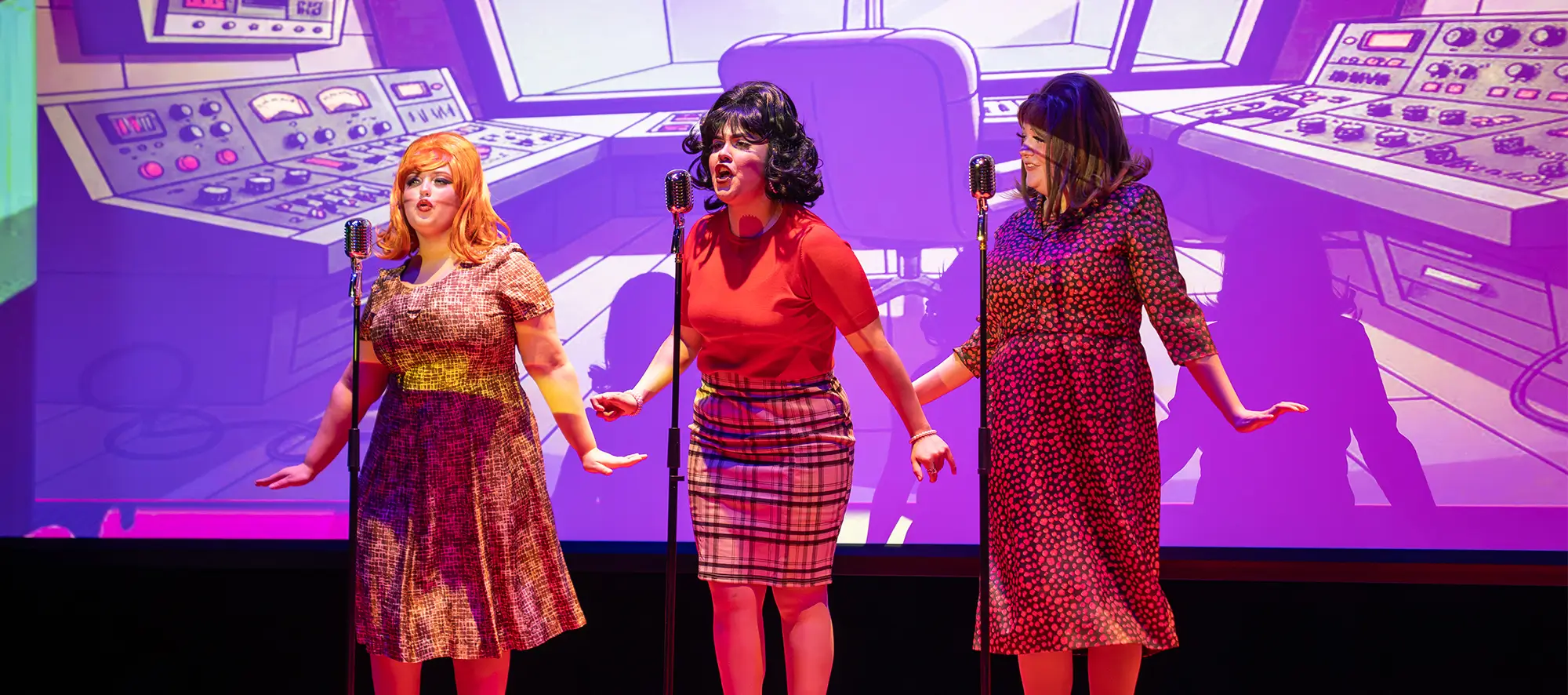 Three actresses on stage signing. 
