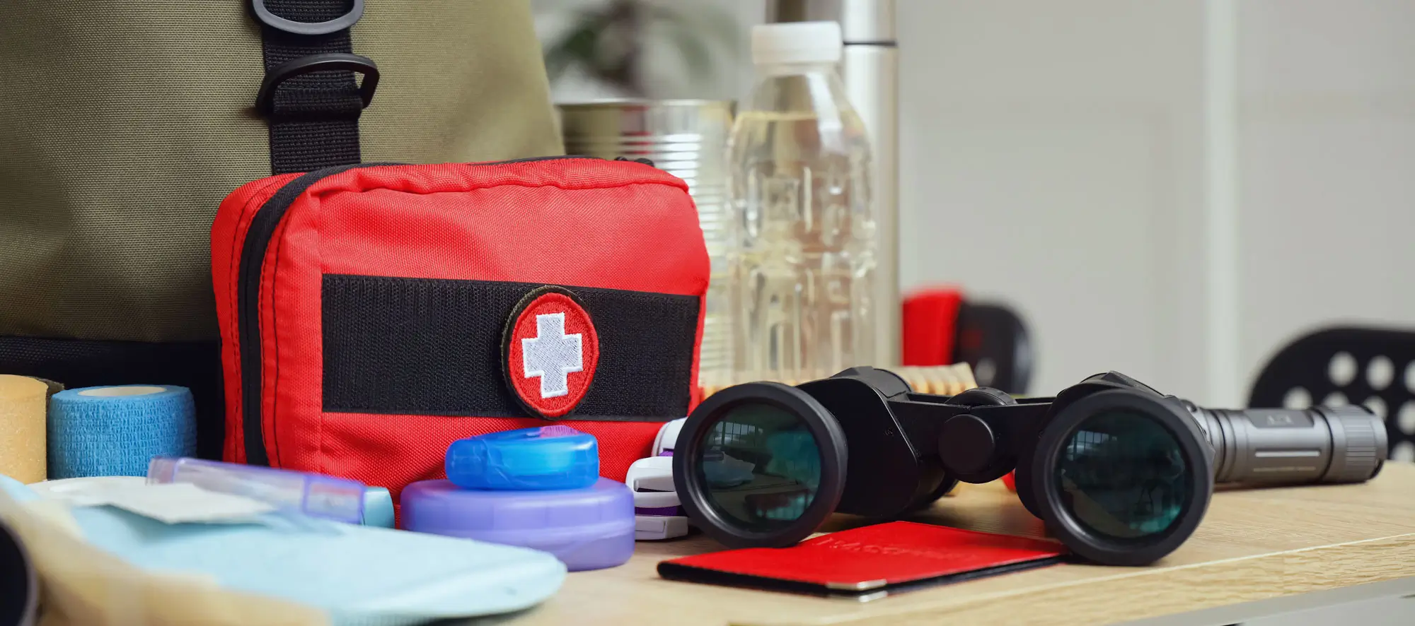 School desks with emergency backpack, first aid kit and necessities in classroom, closeup