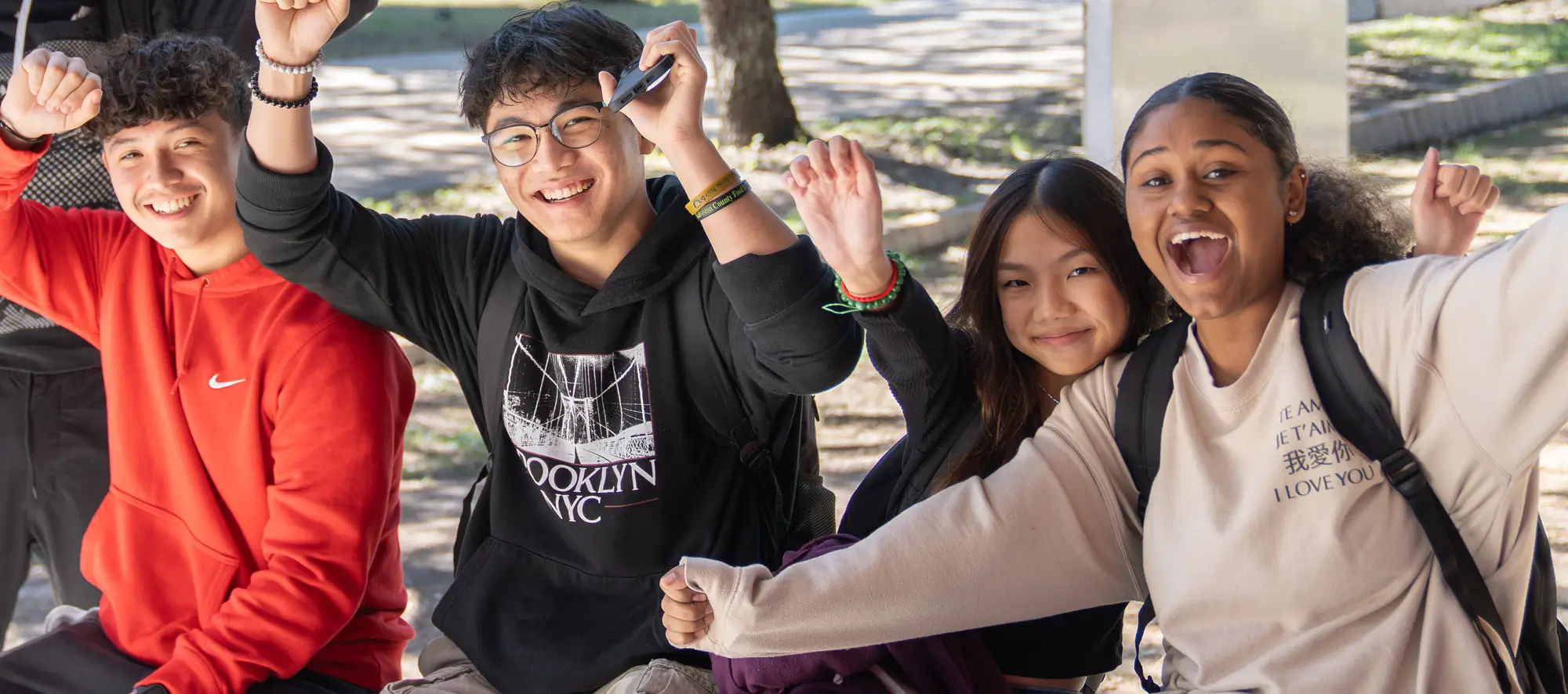 Students gleefully putting their hands in the air.