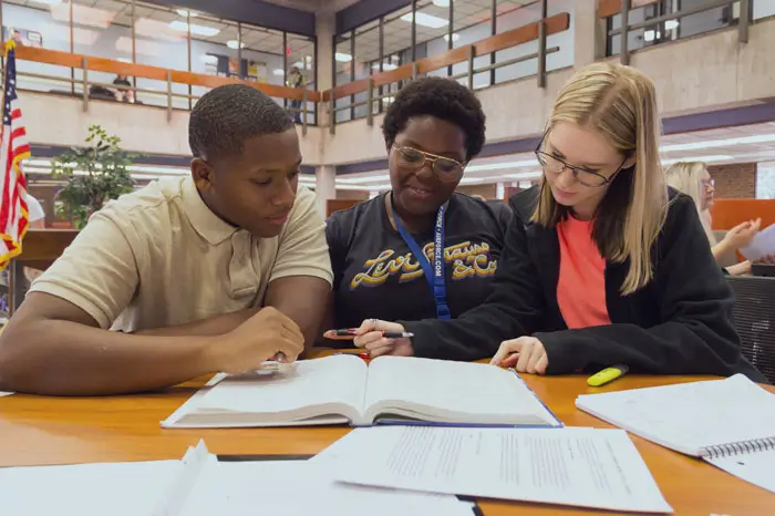 Three students studying together in the library